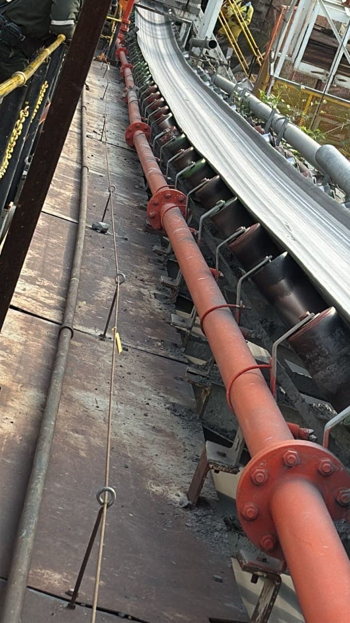 A curved conveyor run with the idler set and belt line visible from the walkway