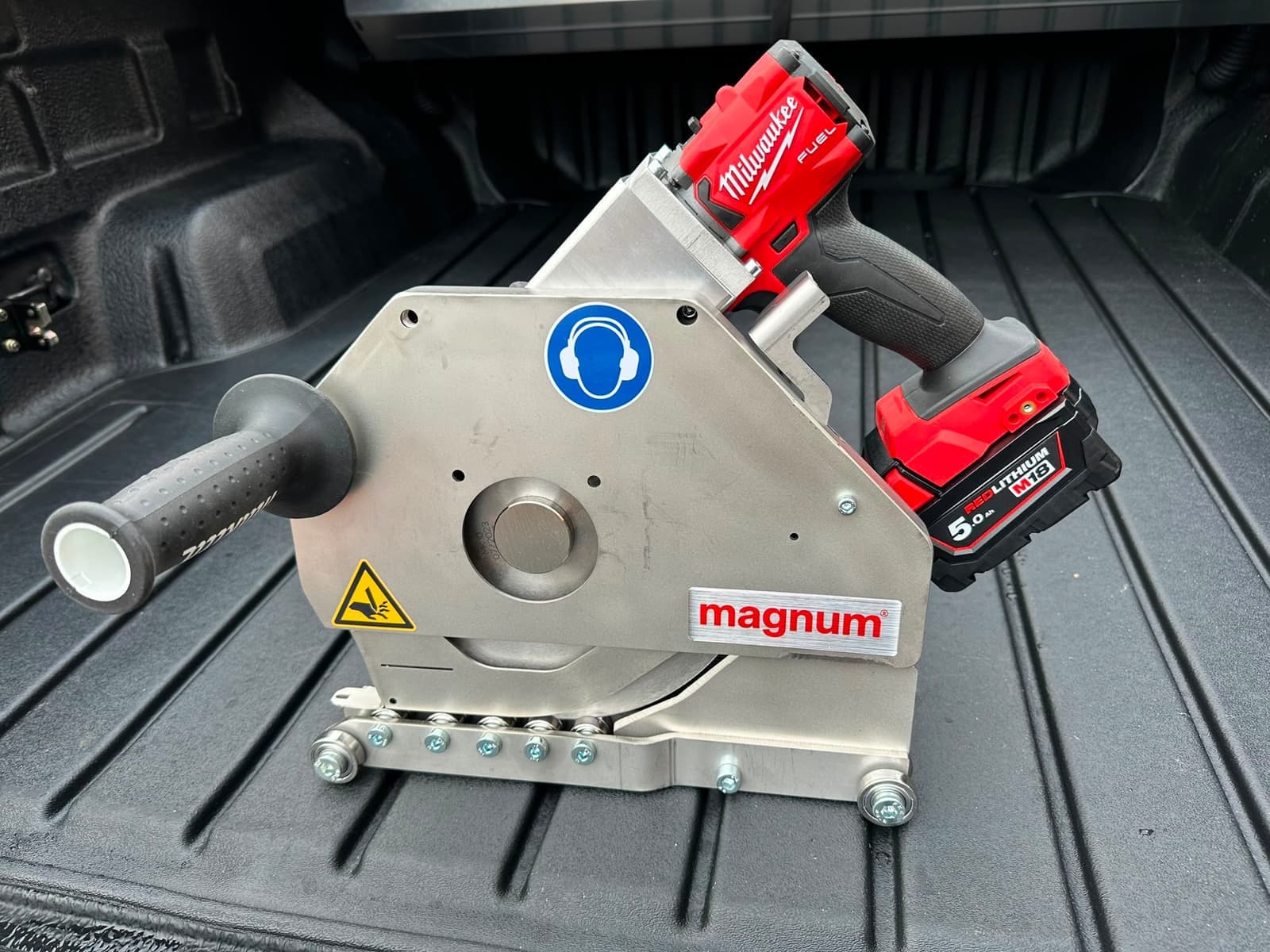 Close-up of the Magnum belt cutter head with its guide plate and cordless drill drive