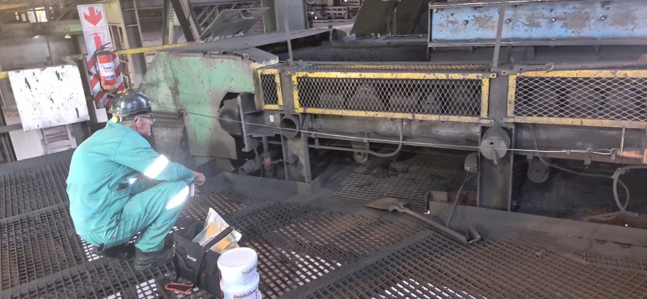 Kia-Kaha Mining's engineer inspecting a stationary conveyor and screen on a mine plant, with an inspection lamp and tools